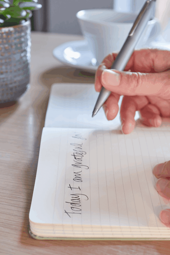 Close-up of hands with a journal, pen,