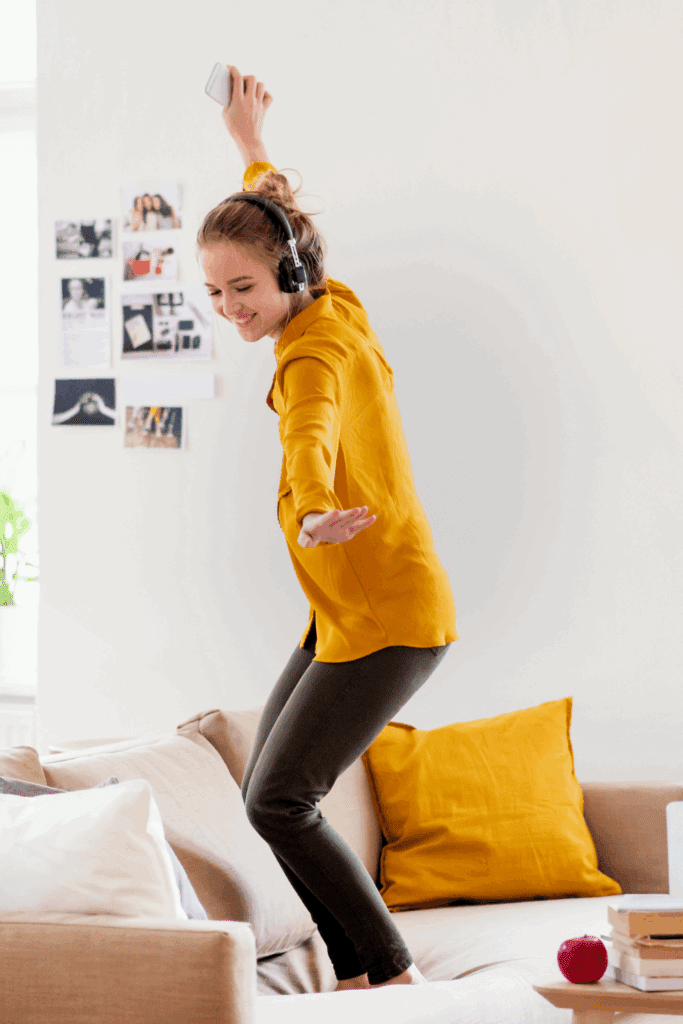 WOMAN DANCING ON SOFA RECONNECTING WITH LIFE