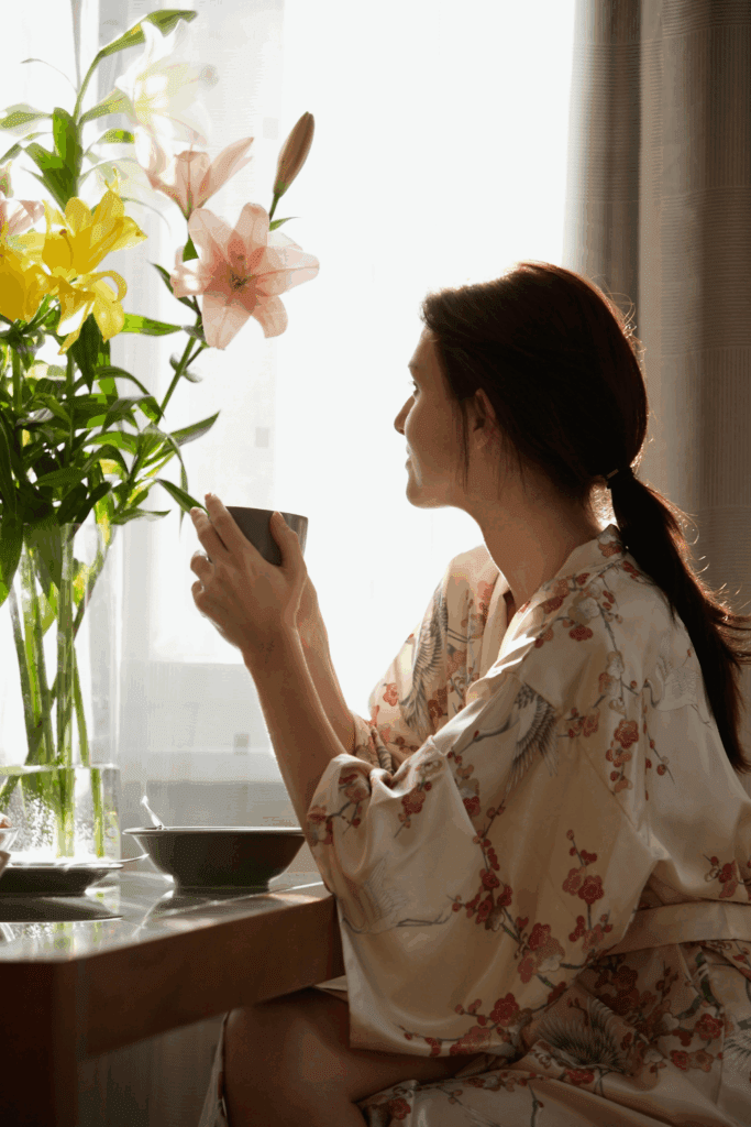 WOMAN SITTING DRINKING TEA LOOKING THROUGH WINDOW STOP Living on Autopilot