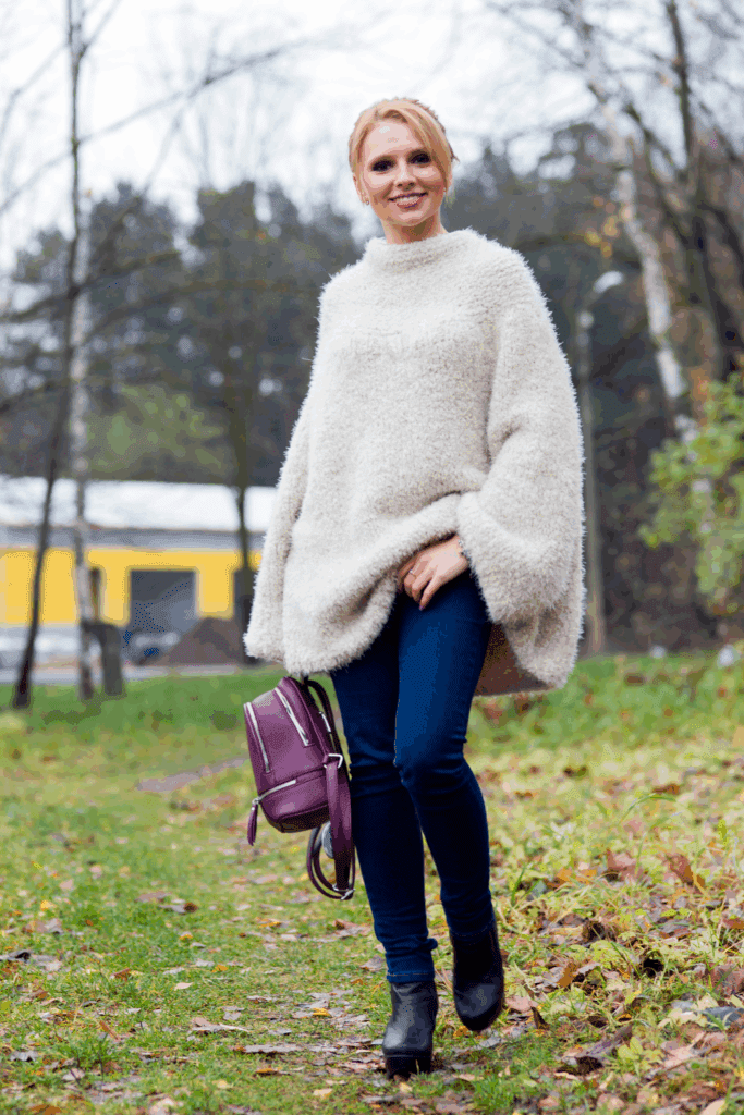 Effortlessy put-together for the holidays in cream sweater and dark jeans
